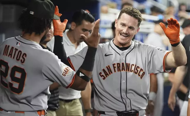 San Francisco Giants' Matt Chapman, right, reacts after hitting a solo home run during the fourth inning of a baseball game against the Miami Marlins, Friday, May 30, 2025, in Miami. (AP Photo/Lynne Sladky)