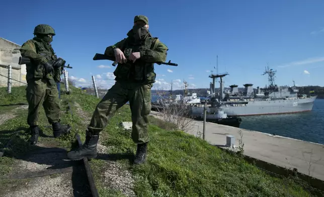 FILE - Russian soldiers guard a pier where two Ukrainian naval vessels are moored, in Sevastopol, on the Crimean Peninsula, March 5, 2014. (AP Photo, File)