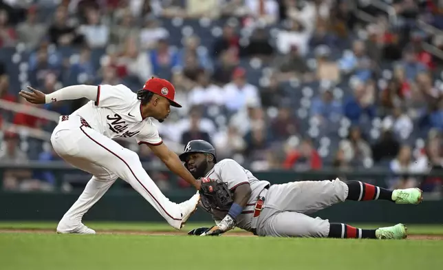 Atlanta Braves' Michael Harris II is tagged out by Washington Nationals third baseman José Tena while attempting to advance to third base on a fielder choice thrown by shortstop CJ Abrams on a ball hit by Nick Allen during the second inning of a baseball game in Washington, Tuesday, May 20, 2025. (AP Photo/Terrance Williams)