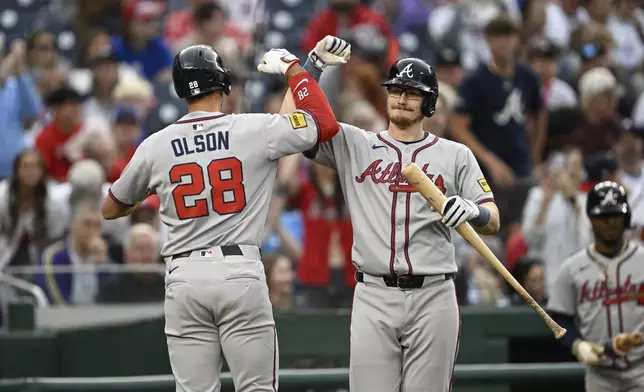 Atlanta Braves' Matt Olson (28) is greeted by Sean Murphy after hitting a solo home run against Washington Nationals pitcher Mitchell Parker during the first inning of a baseball game in Washington, Tuesday, May 20, 2025. (AP Photo/Terrance Williams)