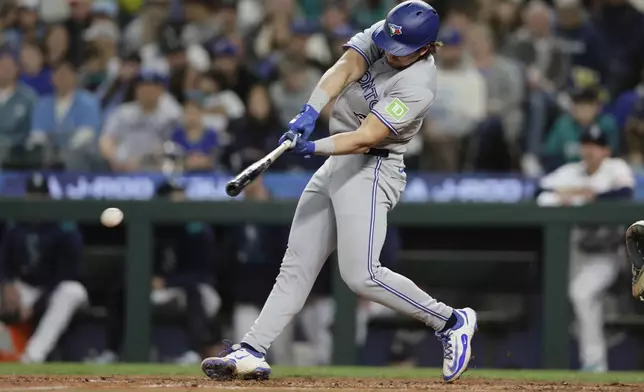 Toronto Blue Jays' Addison Barger hits an RBI single against the Seattle Mariners during the eighth inning of a baseball game, Saturday, May 10, 2025, in Seattle. (AP Photo/John Froschauer)