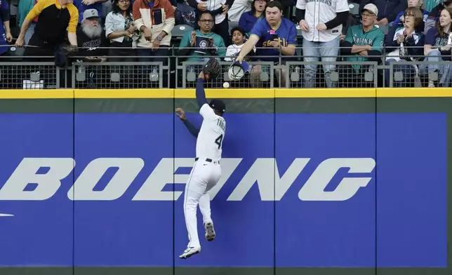 Seattle Mariners right fielder Leody Taveras leaps but is unable to catch the home run hit by Toronto Blue Jays' Bo Bichette during the fifth inning of a baseball game, Saturday, May 10, 2025, in Seattle. (AP Photo/John Froschauer)