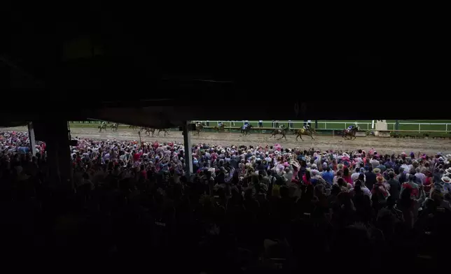 Fans watch as Good Cheer ridden by Luis Saez crosses the finish line to win the 151st running of the Kentucky Oaks horse race at Churchill Downs Friday, May 2, 2025, in Louisville, Ky. (AP Photo/Jon Cherry)