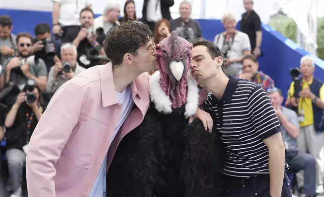 Director Raphael Quenard, left, a person in a bird costume and director Hugo David, right, pose for photographers at the photo call for the film 'I Love Peru' at the 78th international film festival, Cannes, southern France, Sunday, May 18, 2025. (AP Photo/Natacha Pisarenko)