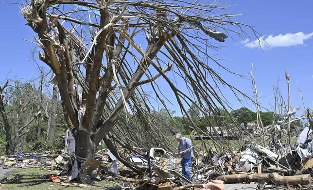 Dennis Clark goes through the remains of his house that was destroyed by severe weather in London, Ky., Saturday, May 17, 2025. (AP Photo/Timothy D. Easley)