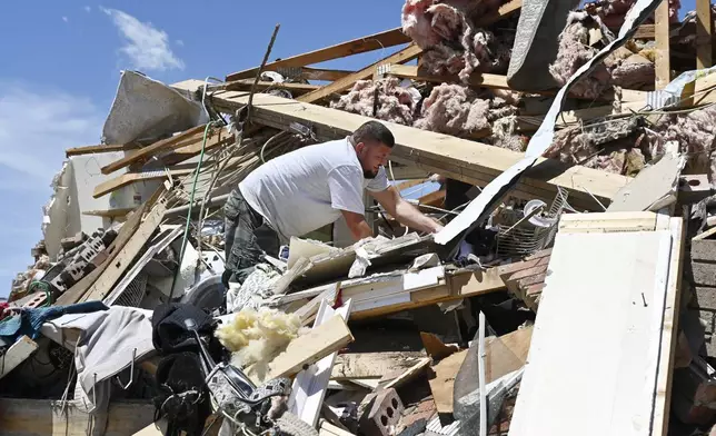 Anthony Broughton digs through the debris of his destroyed home following a severe storm in the Sunshine Hill neighborhood of London, Ky., Saturday, May 17, 2025. (AP Photo/Timothy D. Easley)