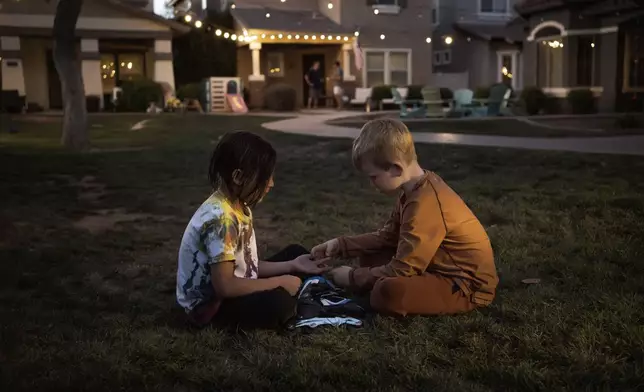 Maverick, left, and Brennan, right, play in Agritopia's "kid pod," a cluster of families with more than 20 kids between them at Agritopia, a community nestled around a plot of agricultural land, on April 21, 2025, in Gilbert, Ariz. (AP Photo/Annika Hammerschlag)