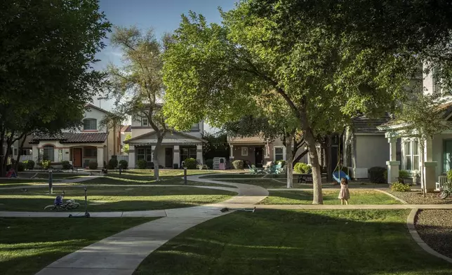 Fae Padron, 4, plays in a "kid pod," a cluster of families with more than 20 kids between them, at Agritopia, a community nestled around a plot of agricultural land, April 21, 2025, in Gilbert, Ariz. (AP Photo/Annika Hammerschlag)