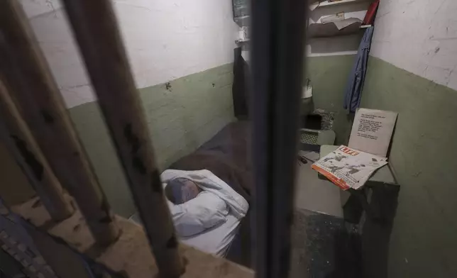 A prison cell with the effigy of an inmate in bed is displayed during a tour guide of the former Alcatraz Federal Penitentiary on Alcatraz Island in San Francisco Bay, Ca., Monday, May 5, 2025. (AP Photo/Jed Jacobsohn)