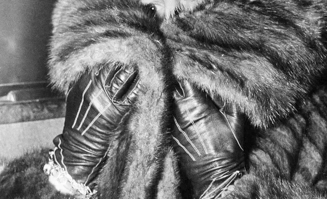 FILE - Mae Capone, the wife of Al Capone, covers her face on the way to visit her husband at the hospital inside the Alcatraz Federal Penitentiary in the San Francisco Bay, California, March 1, 1936. Al Capone was suffering a mental illness brought on by tertiary syphilis. (AP Photo, File)