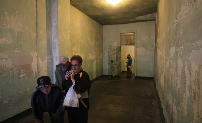 FILE - Visitors tour the cell of former prisoner Robert "The Birdman" Stroud in the hospital area of the Alcatraz Federal Penitentiary in the San Francisco Bay, California, July 7, 2011. (AP Photo/Eric Risberg, File)