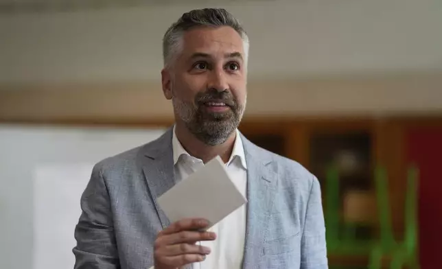 Socialist Party secretary general Pedro Nuno Santos holds his ballot when voting in Portugal's general election at a polling station in Lisbon, Sunday, May 18, 2025. (AP Photo/Armando Franca)