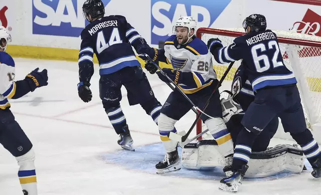 St. Louis Blues' Nathan Walker (26) celebrates his goal against Winnipeg Jets goaltender Connor Hellebuyck (37) during first period NHL playoff action in Winnipeg on Wednesday, April 30, 2025. (John Woods/The Canadian Press via AP)