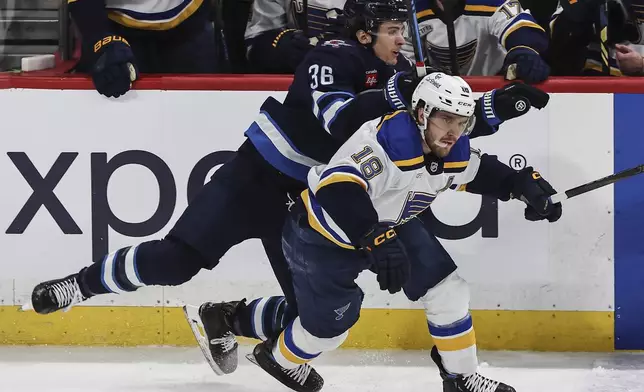 Winnipeg Jets' Morgan Barron (36) and St. Louis Blues' Robert Thomas (18) collide during first period NHL playoff action in Winnipeg on Wednesday, April 30, 2025. (John Woods/The Canadian Press via AP)