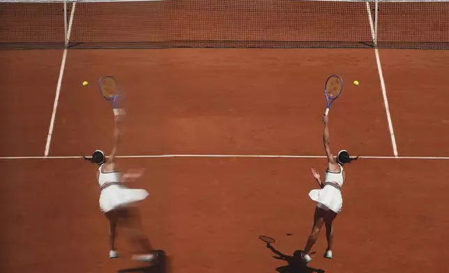 Serbia's Olga Danilovic is reflected in a glass as she serves against Aryna Sabalenka of Belarus during their third round match of the French Tennis Open, at the Roland-Garros stadium, in Paris, Friday, May 30, 2025. (AP Photo/Lindsey Wasson)