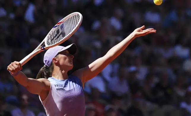 Poland's Iga Swiatek serves against Romania's Jaqueline Cristian during their third round match of the French Tennis Open, at the Roland-Garros stadium, in Paris, Friday, May 30, 2025. (AP Photo/Lindsey Wasson)