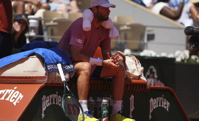 France's Quentin Halys sits as he plays Denmark's Holger Rune during their third round match of the French Tennis Open, at the Roland-Garros stadium, in Paris, Friday, May 30, 2025. (AP Photo/Lindsey Wasson)