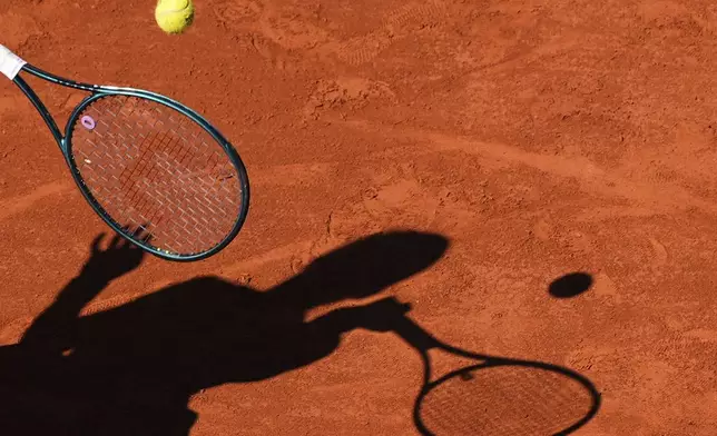 Romania's Jaqueline Cristian shadow is cast upon the court as she plays Poland's Iga Swiatek during their third round match of the French Tennis Open, at the Roland-Garros stadium, in Paris, Friday, May 30, 2025. (AP Photo/Lindsey Wasson)