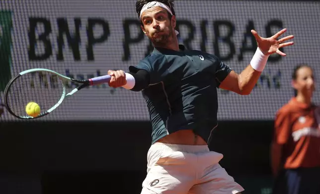 Italy's Lorenzo Musetti returns the ball to Argentina's Mariano Navone during their third round match of the French Tennis Open, at the Roland-Garros stadium, in Paris, Friday, May 30, 2025. (AP Photo/Lindsey Wasson)
