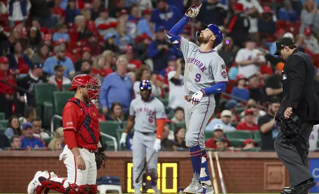 New York Mets' Brandon Nimmo (9) gestures skyward as he crosses home after hitting a solo home run as St. Louis Cardinals' Pedro Pagés, left, looks on during the seventh inning of a baseball game Friday, May 2, 2025, in St. Louis. (AP Photo/Scott Kane)
