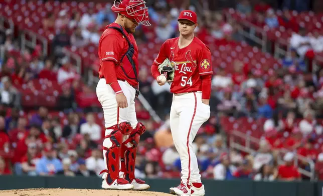 St. Louis Cardinals' Pedro Pagés, left, talks with starting pitcher Sonny Gray (54) on the mound during the second inning of a baseball game against the New York Mets, Friday, May 2, 2025, in St. Louis. (AP Photo/Scott Kane)