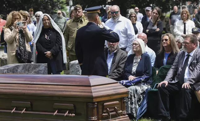 An American flag is folded and given to Virginia "Ginny" Pineiro during the interment for World War II U.S. Army Air Forces Staff Sgt. Eugene Darrigan at the cemetery behind St. Mary's church, Saturday, May 24, 2025, in Wappingers Falls, N.Y. Darrigan was buried in his hometown after his remains were recovered from a World War II bomber that crashed into the water off the coast of Papua New Guinea on March 11, 1944. (AP Photo/Heather Khalifa)
