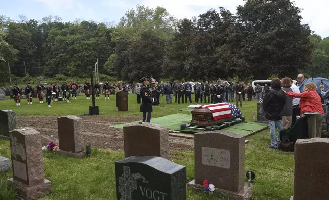 People attend the interment for World War II U.S. Army Air Forces Staff Sgt. Eugene Darrigan at the cemetery behind St. Mary's church, Saturday, May 24, 2025, in Wappingers Falls, N.Y. Darrigan was buried in his hometown after his remains were recovered from a World War II bomber that crashed into the water off the coast of Papua New Guinea on March 11, 1944. (AP Photo/Heather Khalifa)