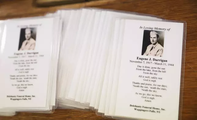 Memorial cards for World War II U.S. Army Air Forces Staff Sgt. Eugene Darrigan sit at the entrance to St. Mary's church, Saturday, May 24, 2025, in Wappingers Falls, N.Y. Darrigan was buried in his hometown after his remains were recovered from the World War II bomber that crashed into the water off the coast of New Guinea on March 11, 1944. (AP Photo/Heather Khalifa)