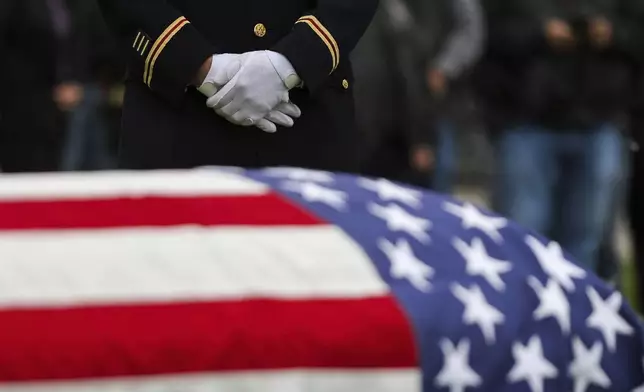 Jason Fetterolf of the U.S. Army Reserve stands during the interment for World War II U.S. Army Air Forces Staff Sgt. Eugene Darrigan inside the cemetery behind St. Mary's church, Saturday, May 24, 2025, in Wappingers Falls, N.Y. Darrigan was buried in his hometown after his remains were recovered from the World War II bomber that crashed into the water off the coast of Papua New Guinea on March 11, 1944. (AP Photo/Heather Khalifa)