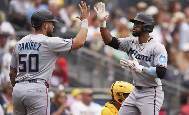 Miami Marlins' Otto Lopez, right, celebrates with teammate Agustin Ramirez after hitting a three-run home run during the fifth inning of a baseball game against the San Diego Padres Wednesday, May 28, 2025, in San Diego. (AP Photo/Gregory Bull)