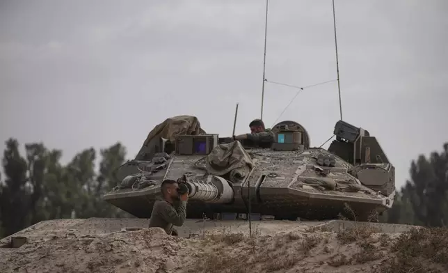 Israeli soldier work on a tank near the border with the Gaza Strip, in southern Israel, Monday, May 19, 2025. (AP Photo/Ohad Zwigenberg)
