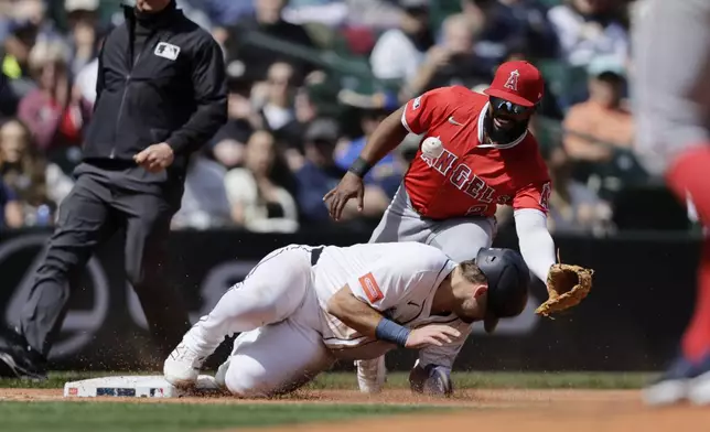 Seattle Mariners' Cal Raleigh reaches third as the ball bounces away from Los Angeles Angels third baseman Luis Rengifo during the third inning of a baseball game, Wednesday, April 30, 2025, in Seattle. (AP Photo/John Froschauer)