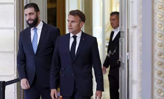 Syria's interim President Ahmad al-Sharaa, left, and French President Emmanuel Macron arrive for a joint press conference at the Elysee Palace in Paris, Wednesday, May 7, 2025. (Stephanie Lecocq/Pool via AP)