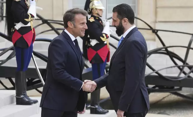 French President Emmanuel Macron, left, shakes hands with Syria's interim President Ahmad al-Sharaa before their talks Wednesday, May 7, 2025 at the Elysee Palace in Paris. (AP Photo/Michel Euler)