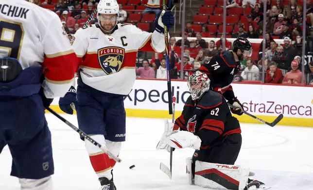 Florida Panthers' Aleksander Barkov, right, celebrates his goal with Florida Panthers' Matthew Tkachuk (19) as Carolina Hurricanes goaltender Pyotr Kochetkov (52) looks on during the third period of Game 2 of the NHL hockey Stanley Cup Eastern Conference finals in Raleigh, N.C., Thursday, May 22, 2025. (AP Photo/Karl DeBlaker)