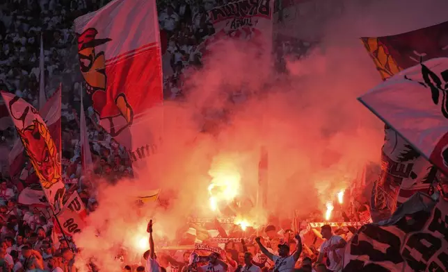 VfB Stuttgart supporters burn flares and wave flags during the German soccer cup, DFB Pokal, final match between Arminia Bielefeld and VfB Stuttgart at Olympiastadion in Berlin, Germany, Saturday, May 24, 2025. (AP Photo/Matthias Schrader)