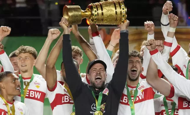 Stuttgart's head coach Sebastian Hoeness raises the trophy after his team won the German soccer cup, DFB Pokal, final match between Arminia Bielefeld and VfB Stuttgart at Olympiastadion in Berlin, Germany, Saturday, May 24, 2025. (AP Photo/Matthias Schrader)