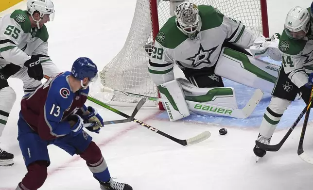 Colorado Avalanche right wing Valeri Nichushkin (13) shoots the puck past Dallas Stars defenseman Thomas Harley (55) as Stars goaltender Jake Oettinger (29) covers the net in the first period of Game 6 of an NHL hockey first-round playoff series Thursday, May 1, 2025, in Denver. (AP Photo/David Zalubowski)