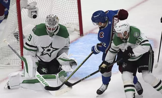 Colorado Avalanche left wing Artturi Lehkonen, center, shoots against Dallas Stars goaltender Jake Oettinger, left, after driving past defenseman Ilya Lyubushkin, right, in the first period of Game 6 of an NHL hockey first-round playoff series Thursday, May 1, 2025, in Denver. (AP Photo/David Zalubowski)