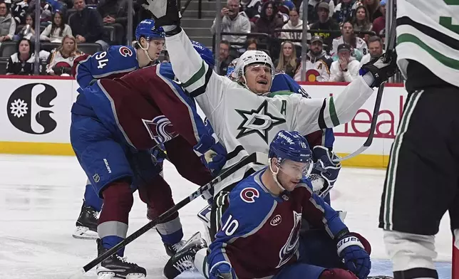 Dallas Stars center Roope Hintz, center top, celebrates after driving past Colorado Avalanche defenseman Ryan Lindgren, front left, and center Charlie Coyle (10) to score in the second period of Game 6 of an NHL hockey first-round playoff series Thursday, May 1, 2025, in Denver. (AP Photo/David Zalubowski)
