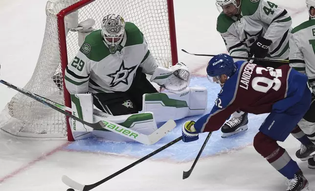 Colorado Avalanche left wing Gabriel Landeskog, bottom right, shoots the puck as Dallas Stars defenseman Cody Ceci (44) and goaltender Jake Oettinger, left, cover in the first period of Game 6 of an NHL hockey first-round playoff series Thursday, May 1, 2025, in Denver. (AP Photo/David Zalubowski)