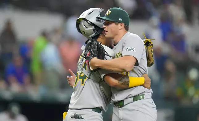 Oakland Athletics pitcher Mason Miller, right, and catcher Jhonny Pereda react after defeating the Texas Rangers 3-0 during a baseball game Thursday, May 1, 2025, in Arlington, TX. (AP Photo/Julio Cortez)