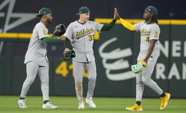 Oakland Athletics outfielders, from left, Miguel Andujar, JJ Bleday and Lawrence Butler react following a baseball game against the Texas Rangers Thursday, May 1, 2025, in Arlington, TX. (AP Photo/Julio Cortez)