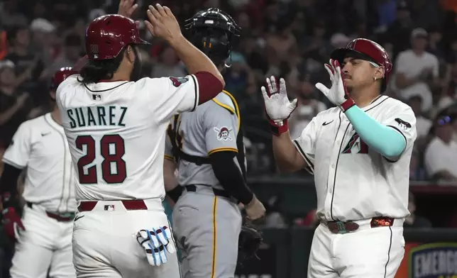 Arizona Diamondbacks' Josh Naylor, right, celebrates with Eugenio Suárez (28) after hitting a two-run home run against the Pittsburgh Pirates in the fifth inning during a baseball game, Monday, May 26, 2025, in Phoenix. (AP Photo/Rick Scuteri)