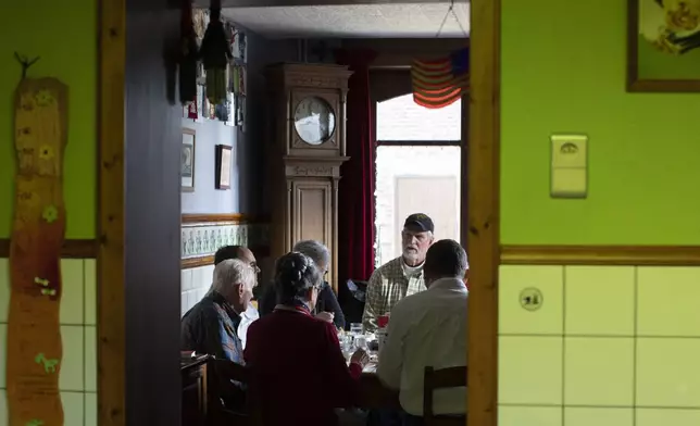 FILE- U.S. Battle of the Bulge veteran Arthur Jacobson, left, and his family have a lunch in the dining room of the WWII Remember Museum 39-45 in Thimister-Clermont, Belgium, Dec. 10, 2019. (AP Photo/Virginia Mayo)