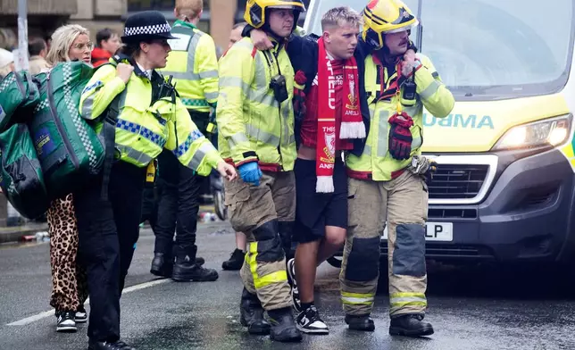 Police and emergency personnel deal with an incident on Water Street near the Liver Building in Liverpool after a car collided with pedestrians during the Premier League winners parade, in Liverpool, England, Monday May 26, 2025. (Owen Humphreys/PA via AP)