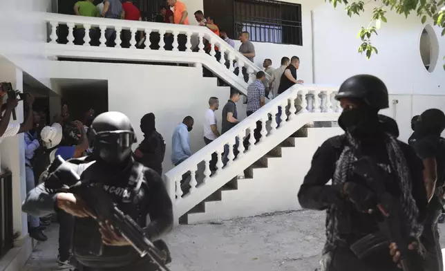 Colombians and Haitians who are accused of involvement in the 2021 assassination of Haitian President Jovenel Moise are escorted in handcuffs to their court hearing in Port-au-Prince, Haiti, Monday, May 26, 2025. (AP Photo/Odelyn Joseph)