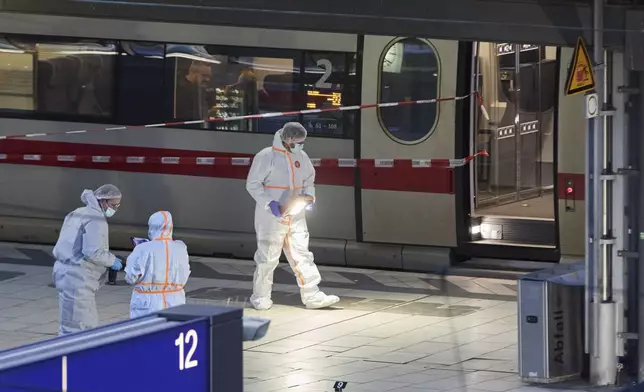 Investigators work at Hamburg, Germany's Central Station on Friday, May 23, 2025, after several people were injured in a knife attack. (Georg Wendt/dpa via AP)