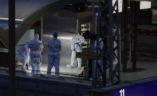 Investigators work at Hamburg, Germany's Central Station on Friday, May 23, 2025, after several people were injured in a knife attack. (Georg Wendt/dpa via AP)