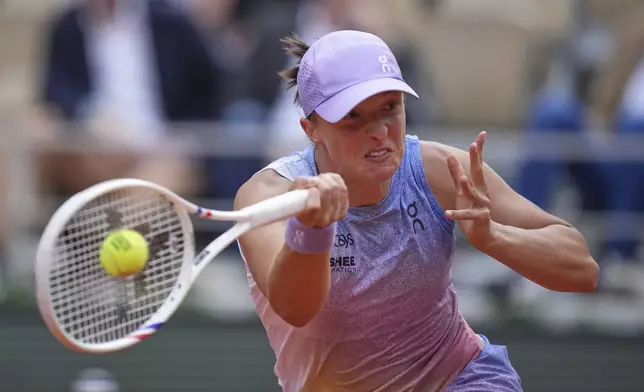 Poland's Iga Swiatek returns the ball to Britain's Emma Raducanu during their second round match of the French Tennis Open, at the Roland-Garros stadium, in Paris, Wednesday, May 28, 2025. (AP Photo/Christophe Ena)